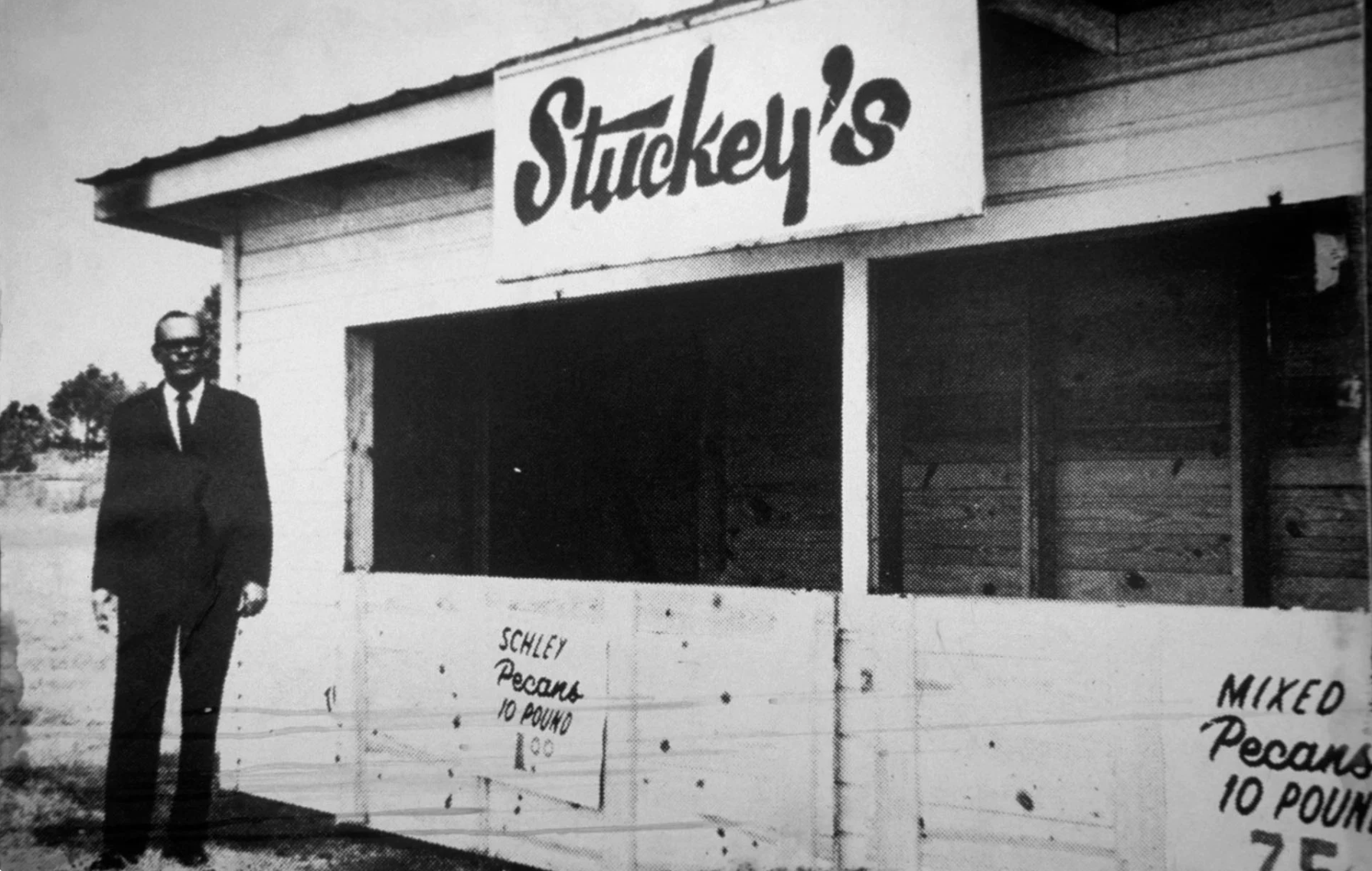 Williamson S. Stuckey Sr. posa con una replica del stand original de 1937 (1962)